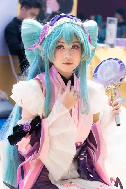 Cosplayer portraying character with blue hair and fan