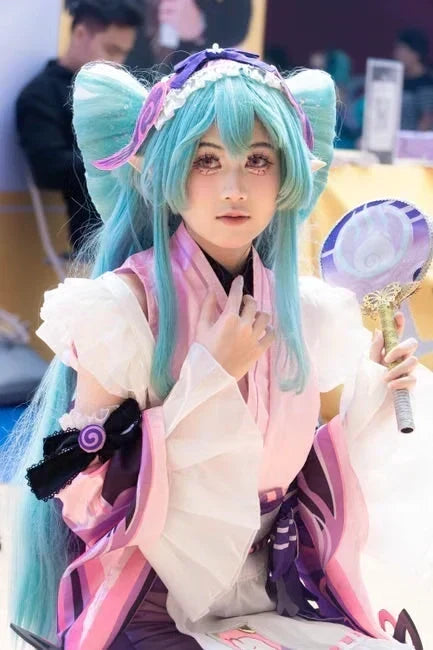 Cosplayer portraying character with blue hair and fan
