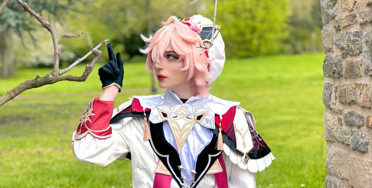 A cosplayer with short pink hair in a white and red knight outfit sitting on a stone wall, featured as the hero image for the koollia new arrivals collection.