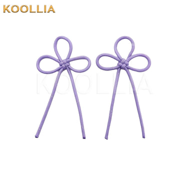 A pair of pale lavender purple decorative cord bows made from thin woven rope, styled into traditional decorative knots with hanging ends against a white background.