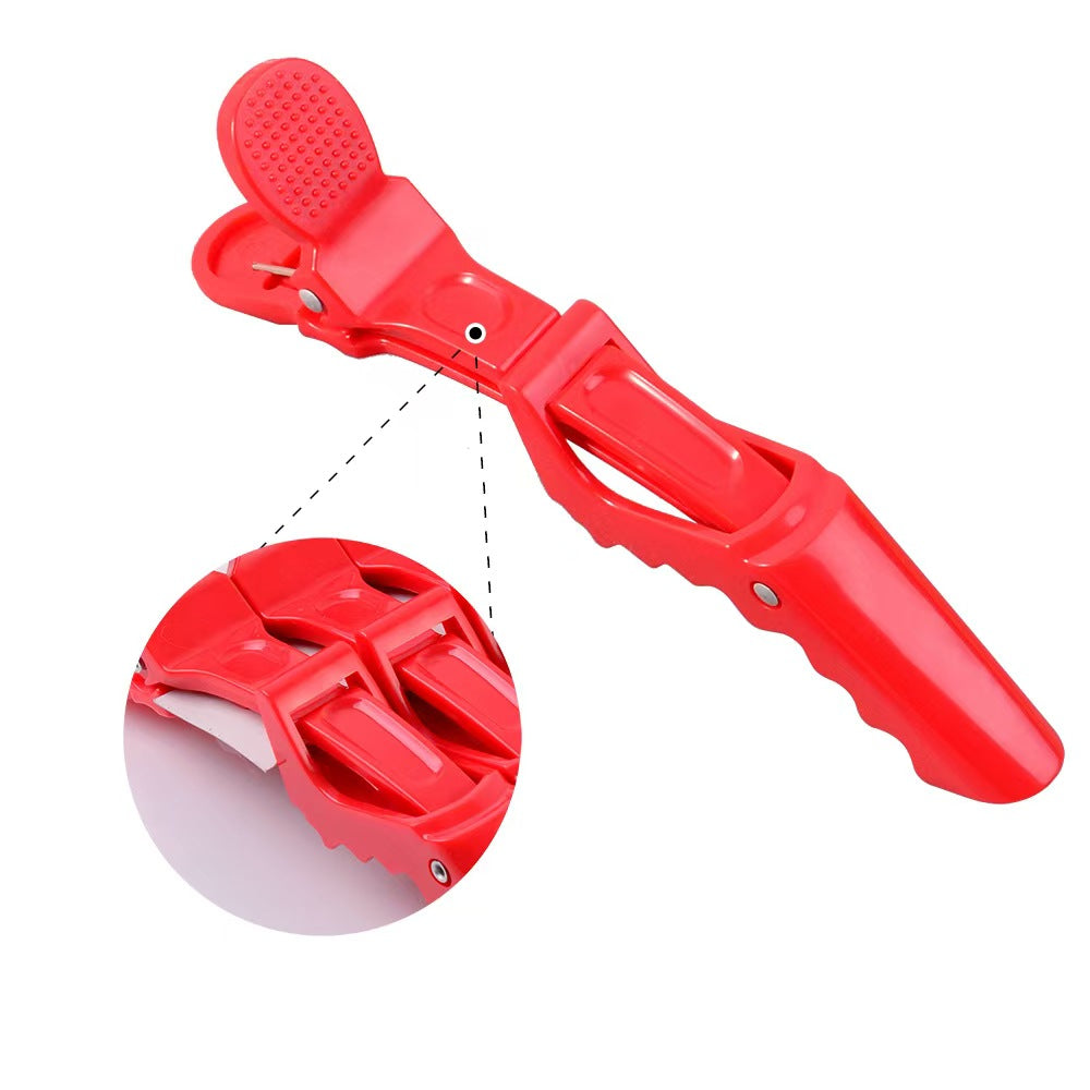 "Professional red alligator hair clip for cosplay wig styling and sectioning by Koollia, featuring a double-hinged design with a detailed close-up on a white background."